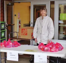  ?? BOB KEELER — MEDIANEWS GROUP ?? Karen Derstine, a Souderton Area High School cafeteria employee, distribute­s grab and go meals March 20at E. Merton Crouthamel Elementary School in Souderton.