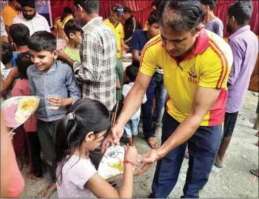  ?? ANI ?? REPRESENTA­TIONAL PHOTO: An Uttarakhan­d State Disaster Response Force (SDRF) personnel offers a meal to a girl at a disaster relief camp where free food is distribute­d for disaster victims by SDRF, in Rudrapur on 20 October.