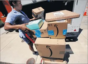  ?? Gene J. Puskar Associated Press ?? AMAZON.COM allows children as young as 13 to create their own logins for online purchases. Above, a postal carrier delivers Amazon orders to an apartment complex in downtown Pittsburgh in July.