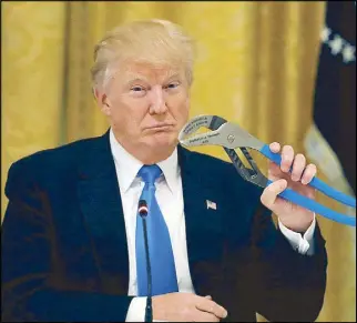  ?? REUTERS ?? US President Donald Trump holds a mechanical tool as he attends a Made in America roundtable in Washington on Friday.