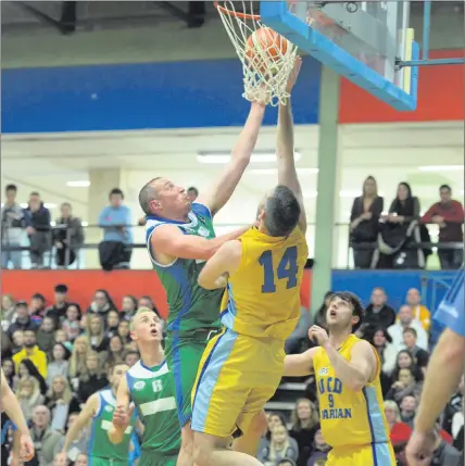  ??  ?? Kieran Donaghy, Tralee Warriors, and Neil Baynes, UCD Marian, under the boards at a packed Tralee Sports Complex during their Superleagu­e match last Saturday night. Photo by Domnick Walsh