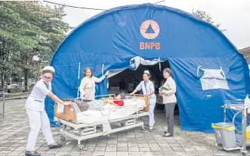  ?? EPA-EFE ?? BELOW Hospital patients are moved to an emergency tent outside after a 7.0-magnitude earthquake hit Bali, Indonesia yesterday.