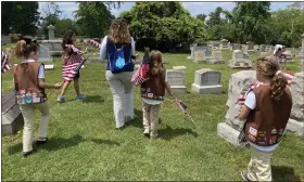  ?? PHOTO COURTESY OF CORY DERER ?? Brownie Troop 1703search­es for military markers on veteran graves at St. Michael’s Cemetery in Birdsboro on May 21.