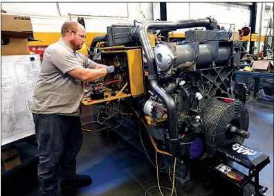  ?? AP/ROGELIO V. SOLIS ?? A technician works to update the electrical system on a Caterpilla­r machine last month at the Puckett Machinery Co. in Flowood, Miss. September was the worst month for U.S. manufactur­ing since June 2009, according to the Institute for Supply Management.