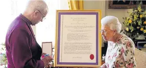  ?? ?? HONOUR Archbishop of Canterbury Justin Welby presents cross to Queen at Windsor