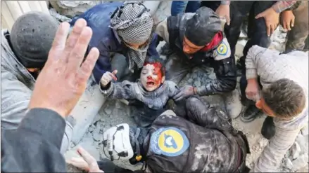  ?? AMEER ALHALBI/AFP ?? Syrian civil defence volunteers, known as the White Helmets, rescue a boy from the rubble following a reported barrel bomb attack on the Bab al-Nairab neighbourh­ood of the northern Syrian city of Aleppo last week.