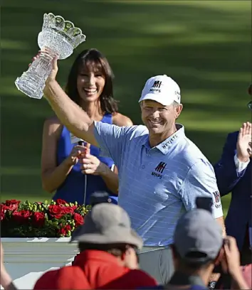  ?? Jeff Lange ?? Retief Goosen, of South Africa, raises the Sam Snead Trophy after he birdied the final two holes to finish out two under par at 66. Jay Haas finished in second place after shooting 67.