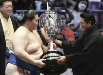  ?? The Yomiuri Shimbun ?? No. 2 maegashira Ichinojo receives the Emperor’s Cup after winning the Nagoya Grand Tournament at Dolphins Arena in Nagoya on Sunday.
