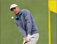  ?? Matt Slocum / Associated Press ?? Scottie Scheffler chips to the second hole during the third round at the Masters at Augusta National on Saturday. Scheffler is leading by three strokes at -9 going into Sunday’s final round after shooting a 1-under 71 on Saturday.