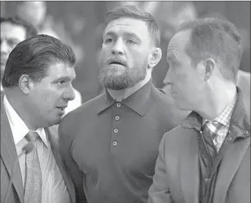  ?? Mary Altaffer Associated Press ?? CONOR MCGREGOR, center, appears with lawyers Jim Walden, right, and John Arlia during his Friday arraignmen­t in Brooklyn federal court. The UFC star is facing charges in the wake of a melee at Barclays Center.