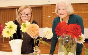  ??  ?? Maureen Graham (left) and Eileen Rogers admire the flowers at the Cox Green Horticultu­ral show. Ref:133774-4