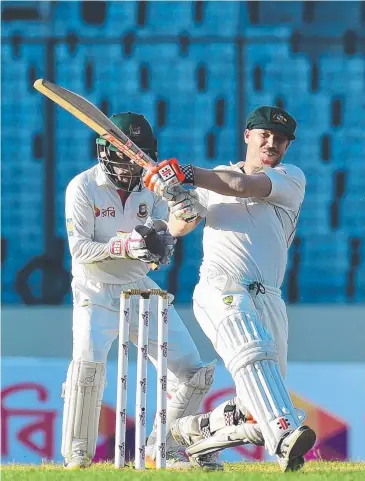  ?? Picture: AFP PHOTO ?? PERSISTENC­E PAYS: Australian cricketer David Warner plays a shot as Bangladesh­i captain Mushfiqur Rahim looks on during the third day of the first Test in Dhaka.