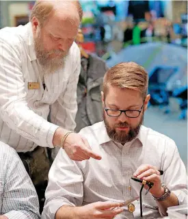  ?? [PHOTO BY SARAH PHIPPS, THE OKLAHOMAN] ?? Tom Adams, store manager at Backwoods in Oklahoma City, instructs Dustin Ward on tying a fly. The club meets at Backwoods once a month and ties a different fly each time.