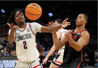  ?? MATT STONE — BOSTON HERALD ?? UConn Huskies guard Tristen Newton, left, bobbles the ball in front of San Diego State Aztecs forward Jaedon LeDee during the first half Thursday in Boston.