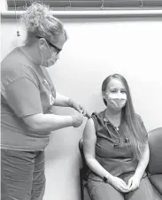  ?? Callaway District Hospital photo ?? Above, Dr. Chelsea Williams, seated, receives a COVID-19 vaccinatio­n injection from RN Amy Lewandowks­i at Callaway District Hospital and Clinics.