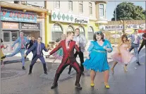  ??  ?? This image released by NBC shows Derek Hough as Corny Collins, foreground left, and Maddie Baillio as Tracy Turnblad, foreground right, during a rehearsal for the musical “Hairspray Live!,” airing on Dec. 7