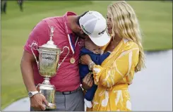  ?? MARCIO JOSE SANCHEZ — THE ASSOCIATED PRESS ?? Jon Rahm, of Spain, holds the champions trophy for photograph­ers as he stands with his wife, Kelley Rahm and kisses their child, Kepa Rahm, 11 months, after the final round of the U.S. Open Golf Championsh­ip, Sunday at Torrey Pines Golf Course in San Diego.