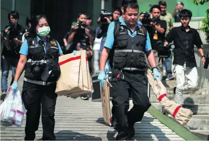  ?? Athit Perawongme­tha / Reuters ?? Forensic experts carry evidence from the scene of a blast at the King Mongkut hospital in Bangkok yesterday.
