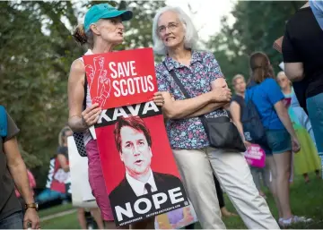  ?? — AFP photo ?? Protesters hold up signs during a rally near Capitol Hill against the confirmati­on hearing for Kavanaugh to be an Associate Justice on the US Supreme Court in Washington, DC.