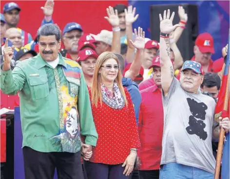  ??  ?? ► Maduro, junto a su esposa Cilia Flores, saluda junto a Maradona, durante su cierre de campaña, ayer.