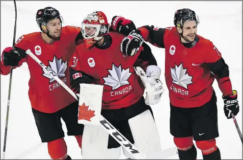  ?? THE CANADIAN PRESS ?? Canada goaltender Kevin Poulin is congratula­ted by teammates Marc-Andre Gragnani (left) and Gilbert Brule following their 1-0 quarter final victory over Finland yesterday at Gangneung. Canada faces Germany in a semifinal on Friday morning.