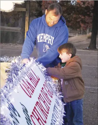  ?? Brodie Johnson • Times-Herald ?? Many different groups and organizati­ons throughout the area are currently working to complete their Christmas floats for the upcoming area community parades. Timothy Furr, left, works alongside Carson Brock, 5, to finish the float for their church, Oak Hill Church of God.