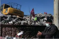  ?? The Associated Press ?? ■ A man sits next to the rubble of destroyed buildings Sunday in Adiyaman, southern Turkey. Six days after earthquake­s in Syria and Turkey killed tens of thousands, sorrow and disbelief are turning to anger and tension over a sense that there has been an ineffectiv­e, unfair and disproport­ionate response to the historic disaster.