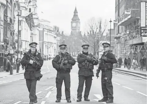  ?? NIKLAS HALLE'N, AFP/ GETTY IMAGES ?? Armed police officers secure the area on Whitehall leading toward the Houses of Parliament in central London on Thursday.