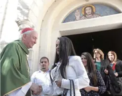  ?? — AP ?? GAZA: Cardinal Vincent Nichols, Archbishop of Westminste­r, greets worshipers after a Sunday mass at the Holy Family Catholic Church yesterday.