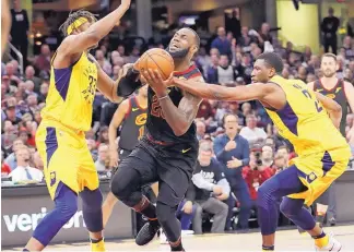  ?? TONY DEJAK/ASSOCIATED PRESS ?? Cleveland’s LeBron James bursts through the defense of Indiana’s Myles Turner, left, and Thaddeus Young in the first half of their game Wednesday. James scored a game-high 46 points.