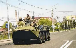  ?? LYNSEY ADDARIO NYT ?? Ukrainian troops ride atop an armored personnel carrier in Kramatorsk, in the Donbas region of Ukraine, on Friday as fighting in the area intensifie­s.