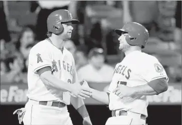  ?? Harry How
Getty Images ?? KIRK NIEUWENHUI­S, left, and Chris Iannetta celebrate after they scored on a single by Johnny Giavotella in the eighth inning. The Angels’ 4-2 victory gave them a sweep of their four-game series against Detroit.