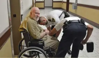  ?? CHRIS CHRISTO / HERALD STAFF FILE ?? 2018 ARRAIGNMEN­T: Court officers adjust Wayne Chapman’s wheelchair after his June 6, 2018, arraignmen­t in Ayer District Court on the lewdness charges he was acquitted of Friday.