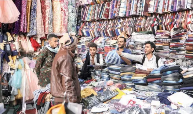  ?? Reuters ?? ↑ People shop for clothes ahead of Eid Al Fitr in Sanaa on Saturday.