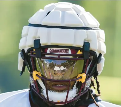  ?? ALEX BRANDON/AP ?? Commanders running back Jonathan Williams wears a Guardian Cap during a practice last week. The NFL is conducting an experiment with the helmet protectors, which they have made mandatory for all players through the second preseason game this year.