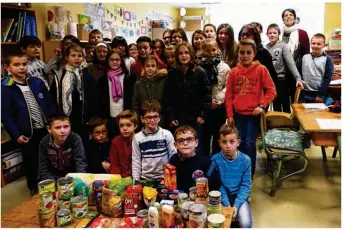  ??  ?? Les enfants sont heureux de remettre à la banque alimentair­e, les denrées collectées dans le calendrier de l’avent inversé proposé à l’école.