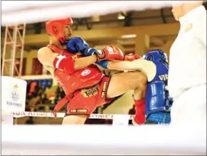  ?? HONG MENEA ?? Kun Khmer boxer Lao Chetra (in red) launches a knee strike at his Vietnamese opponent during the 32nd SEA Games in Cambodia in May 2023.