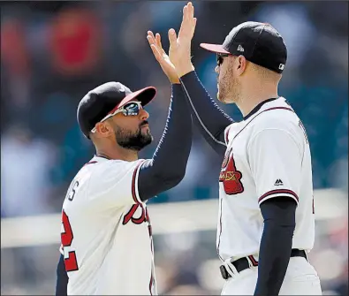  ?? AP/JOHN BAZEMORE ?? First baseman Freddie Freeman (right) and right fielder Nick Markakis celebrate after the Atlanta Braves defeated the St. Louis Cardinals on Wednesday at SunTrust Park in Atlanta. Freeman hit a two-run home run and drove in three runs, and Touki Toussaint pitched into the sixth inning to help the Braves snap a four-game losing streak.