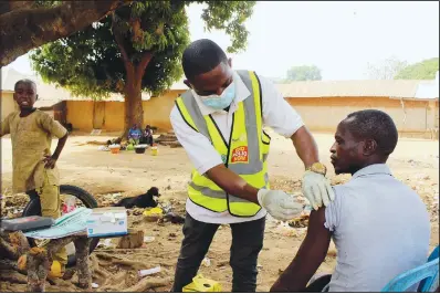  ?? ?? Bawa gives a man the AstraZenec­a covid-19 vaccine in Sabon Kuje.