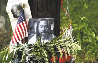  ?? Tom Uhlman / Associated Press 2015 ?? Photos of Sam DuBose hang at a makeshift memorial near where he was shot and killed last year by a former University of Cincinnati police officer during a traffic stop.