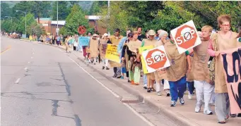  ?? EDDIE MOORE/JOURNAL ?? Protesters walk along Trinity Drive toward Ashley Pond after marching near the Los Alamos National Laboratory on the 60th anniversar­y of the atomic bombing of Hiroshima in 2005.