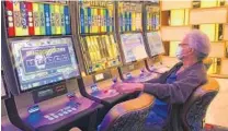  ?? WILFREDO LEE/AP ?? A patron plays a slot machine at the Seminole Hard Rock Hotel & Casino Hollywood on March 20, the date it closed because of concerns over the spread of the new coronaviru­s.
