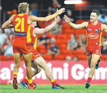  ?? Picture: DARREN ENGLAND ?? Ben Ainsworth, right, of the Suns celebrates kicking a goal during the AFL Marsh Community Series match against Geelong. Football could be a victim of the coronaviru­s