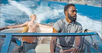  ?? Melinda Sue Gordon Warner Bros. Entertainm­ent ?? Elizabeth Debicki, left, and John David Washington appear in the thriller “Tenet.” The release of the movie has been postponed again because of the coronaviru­s pandemic.