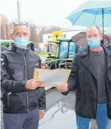  ?? FOTO: ELKE OBERLÄNDER ?? Omira-Mitarbeite­r Peter Haberkorn übergibt das Antwortsch­reiben an Hermann Fischer, den Sprecher der Landwirte.