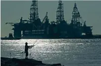  ?? ERIC GAY/ASSOCIATED PRESS FILE PHOTO ?? A man fishes near docked oil drilling platforms in 2020 in Port Aransas, Texas. The Interior Department says a planned sale of two leases in the Gulf of Mexico was being scrapped because of ‘conflictin­g court rulings,’ which it said affected the agency’s ability to work on them. A sale in Alaska was also canceled.