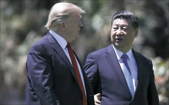  ?? Alex Brandon/Associated Press ?? President Donald Trump and Chinese President Xi Jinping walk together after their meetings last week at Mar-a-Lago in Palm Beach, Fla. Some political analysts have suggested Mr. Trump agreed to drop his major trade issues in exchange for Chinese...