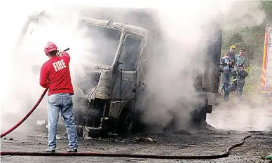  ?? (JJ Landingin) ?? N.P.A. TARGETS – Two trucks loaded with ore concentrat­e were set on fire by suspected NPA guerrillas in Ampucao, Itogon, Benguet, Thursday morning. The trucks had just come from the Philex Mines site.