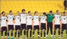  ?? Karim Jaafar
AFP/Getty Images ?? A MOMENT OF SILENCE in Doha allows the Egyptian team to honor the 74 killed in the 2012 Port Said post-match riot in which a young boy died in the arms of one of the national team players.