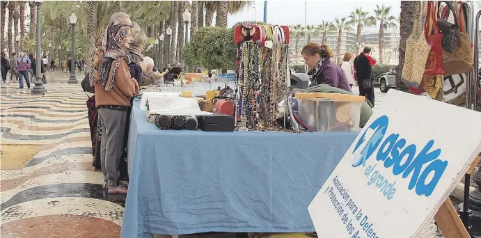  ?? Fotos: Ignacio Gómez ?? Die Tierschütz­er von Asoka profitiere­n von ihrem Stand auf der Explanada in Alicante, wo viele potenziell­e Kunden spazieren gehen.